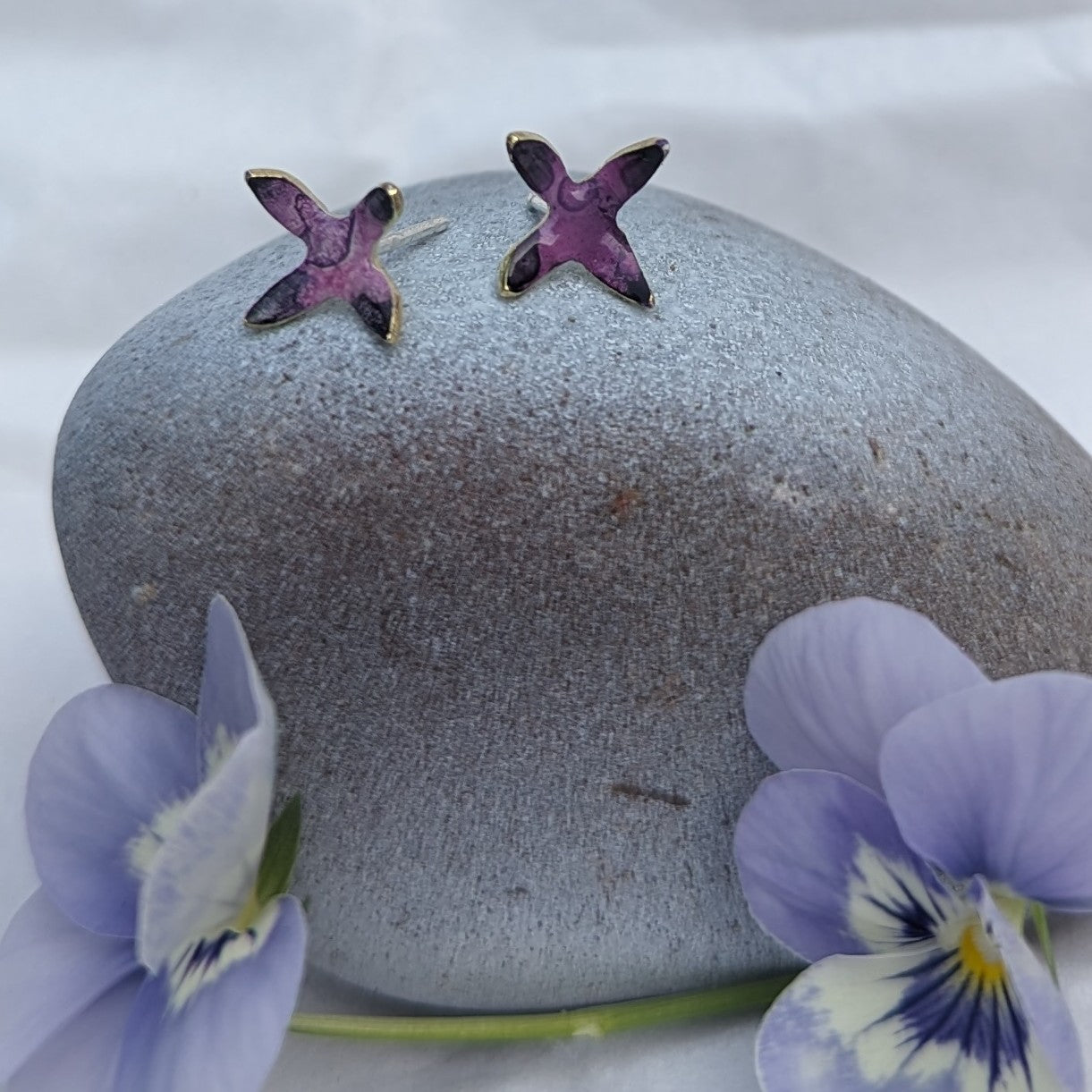 'Theia's Garden' Purple Star Stud Earrings. Earrings displayed on rock