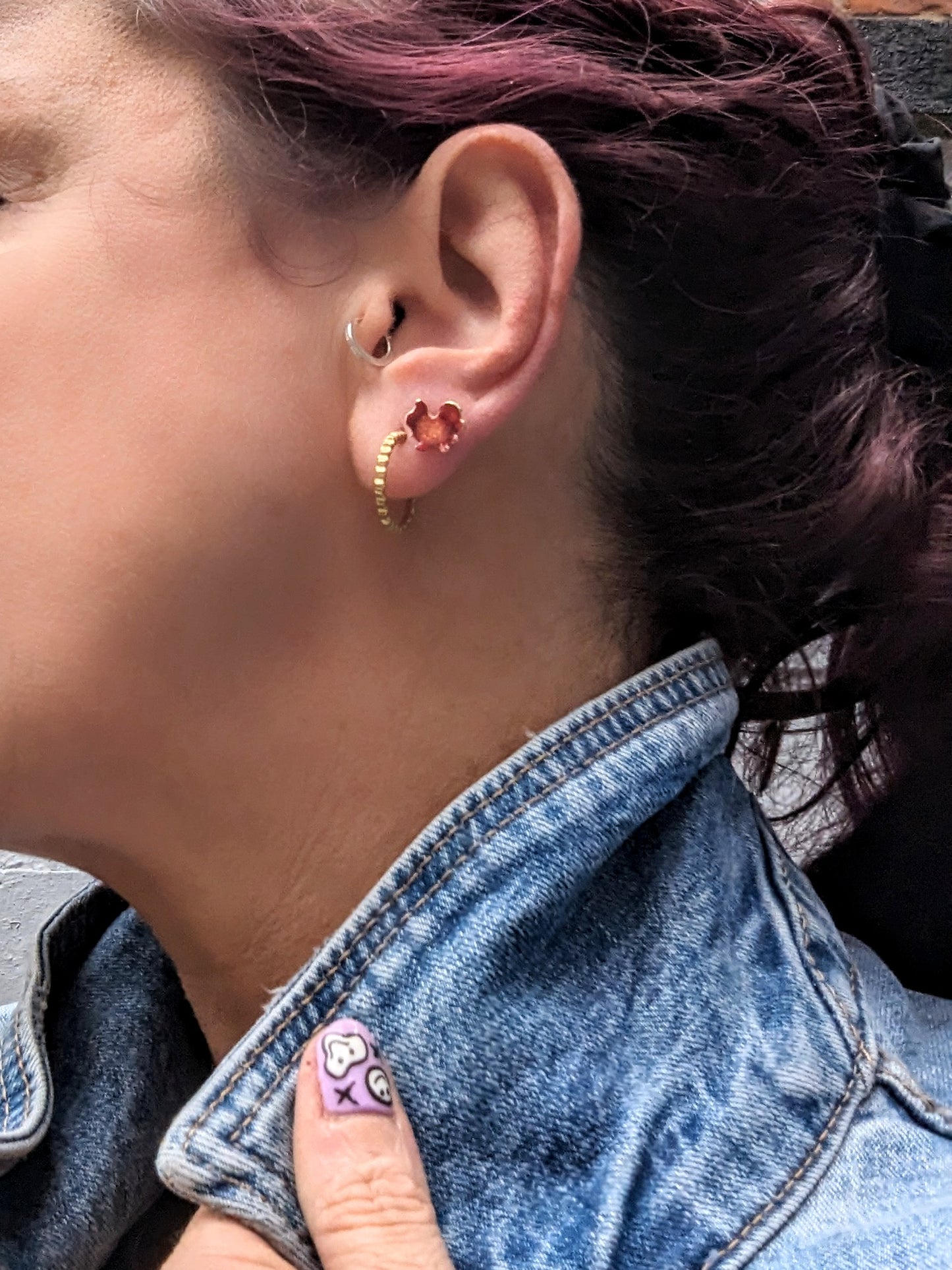 Model wearing red stud earrings 