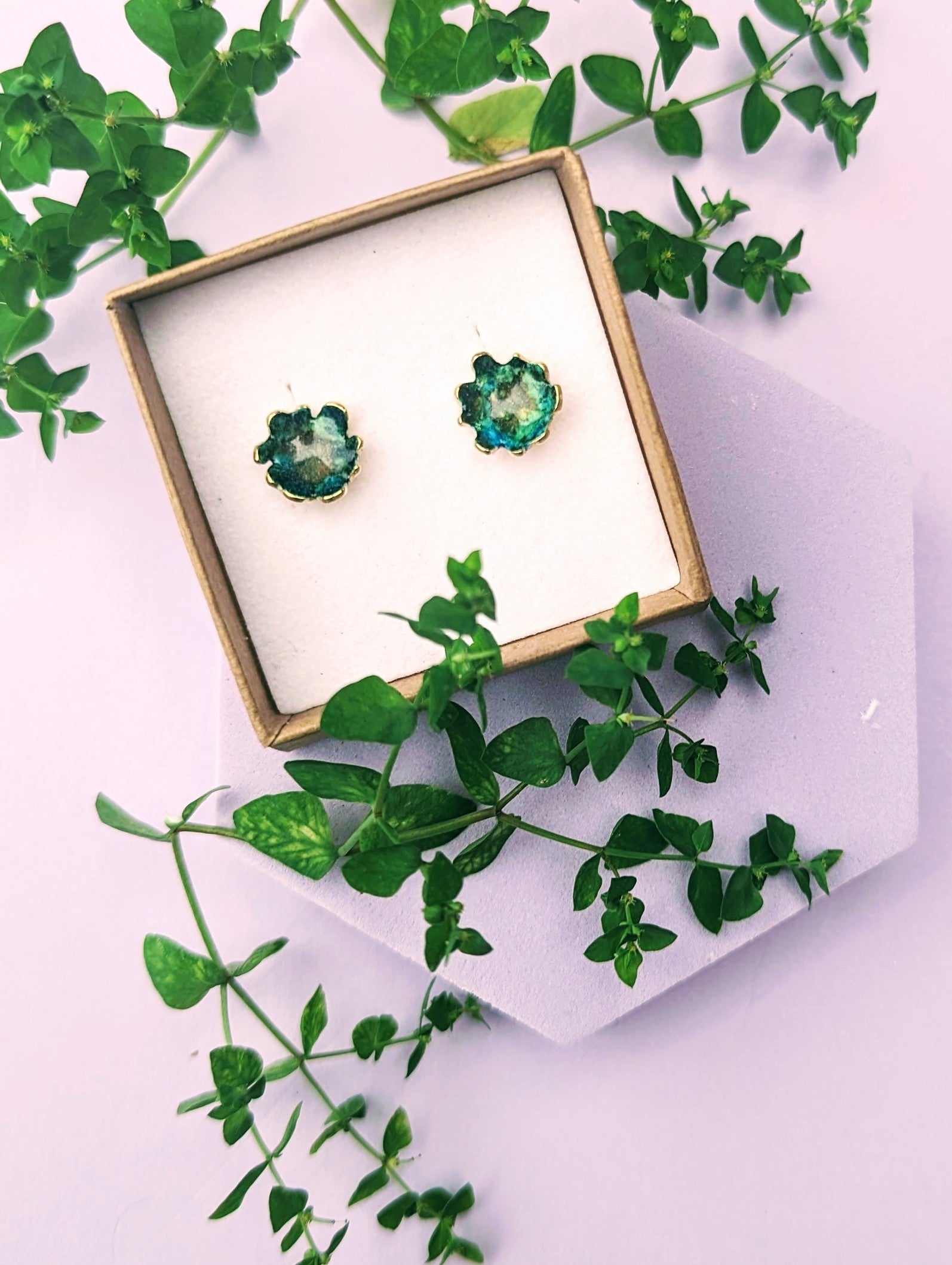 Green stud earrings displayed in Jewellery box