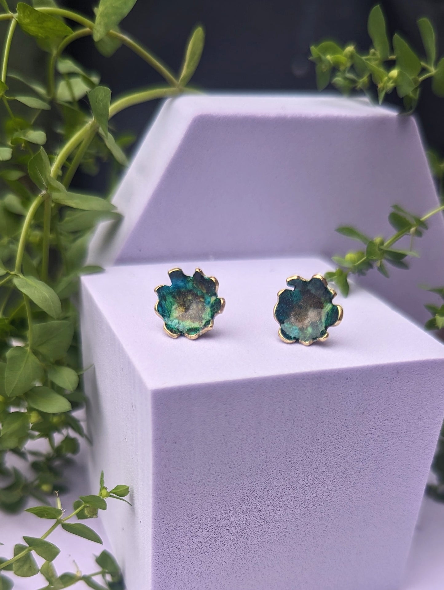 Green stud earrings on display model 