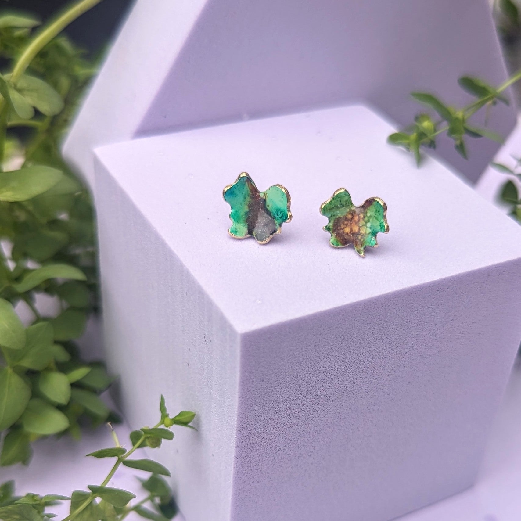 Green stud earrings on display model